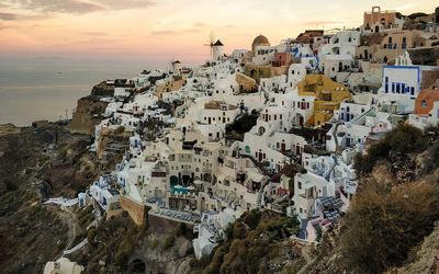 Λευκά κτίρια και μπλε θόλες στη Σαντορίνη με θέα στο Αιγαίο